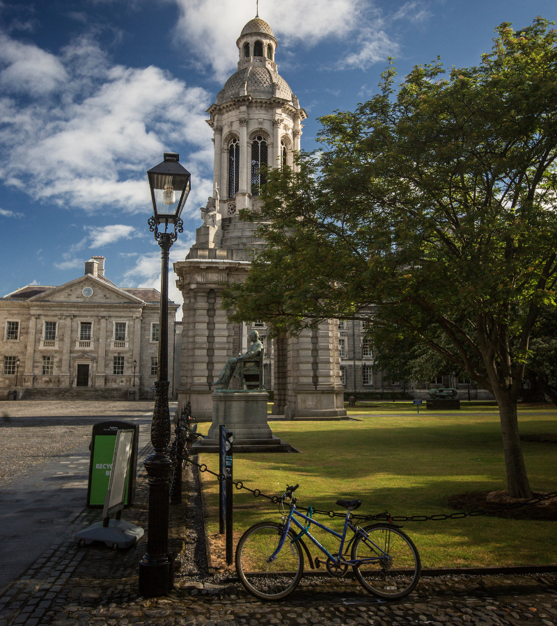 The iconic Campanile bell tower in Trinity College Dublin, with historic architecture and a bicycle in the foreground – The Dawson Hostel accommodation near Trinity College Dublin.