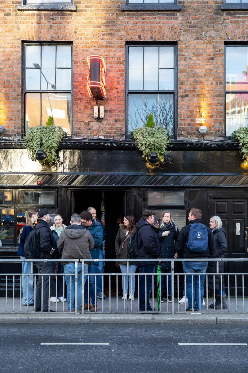 Group of people outside a Dublin pub during a walking tour, one of the best free things to do in Dublin near The Dawson Hostel